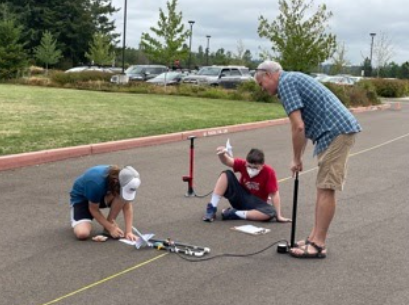 Students finish calculations before launching a rocket.